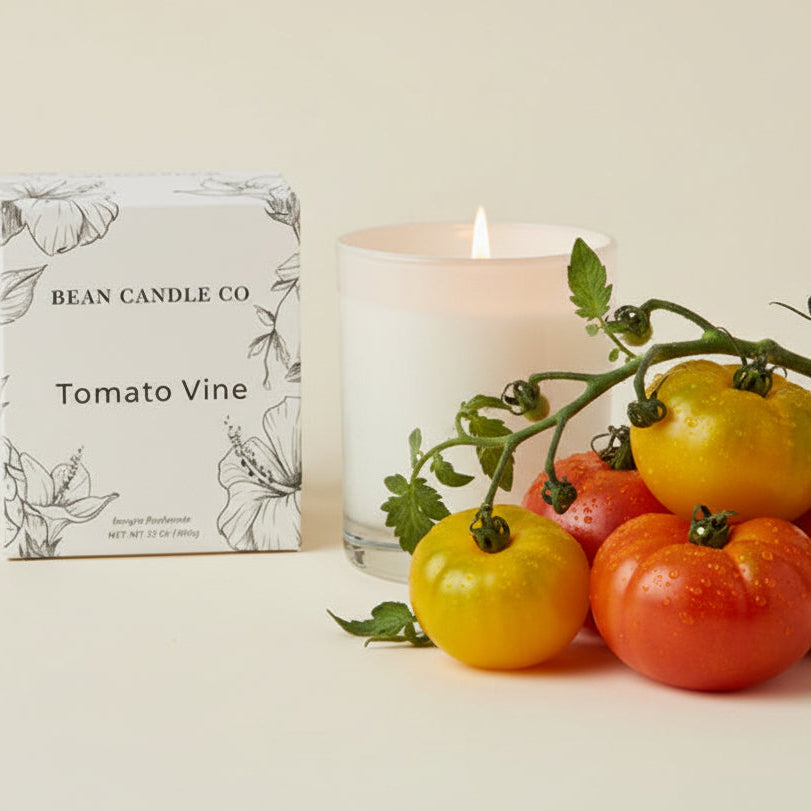 Candle labeled 'Tomato Vine' from Bean Candle Co with a branch of tomatoes on a light background