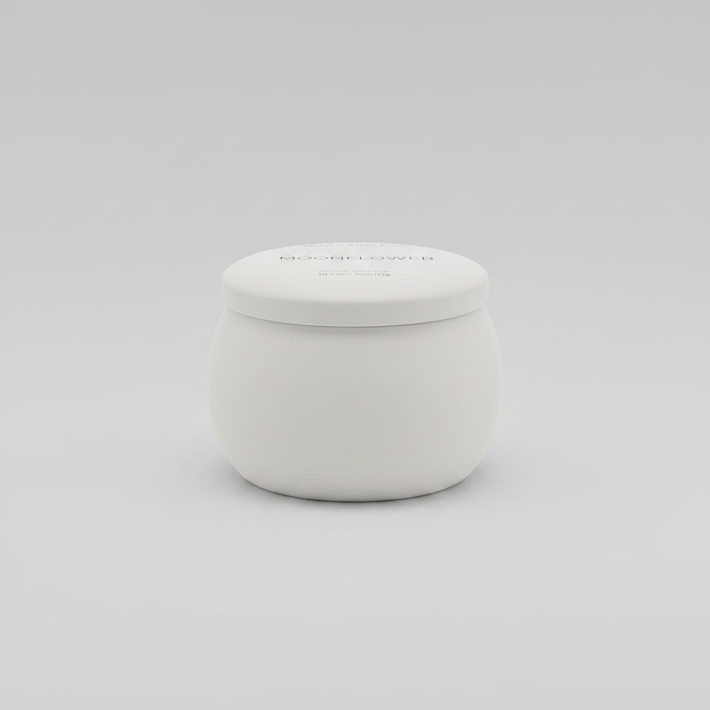 Small white container on a dark surface with a blurred indoor setting in the background