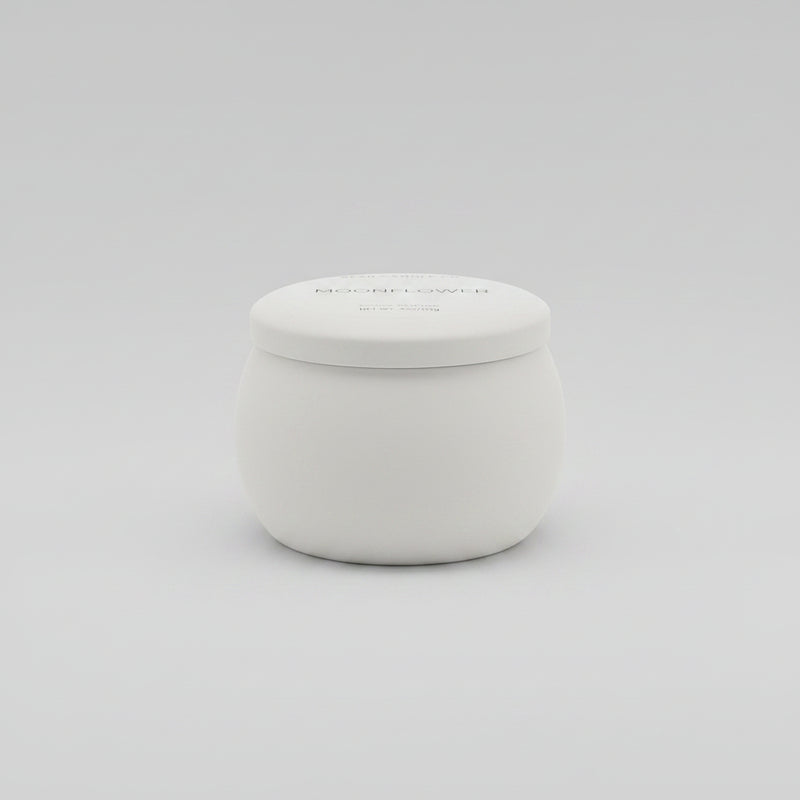 Small white container on a dark surface with a blurred indoor setting in the background